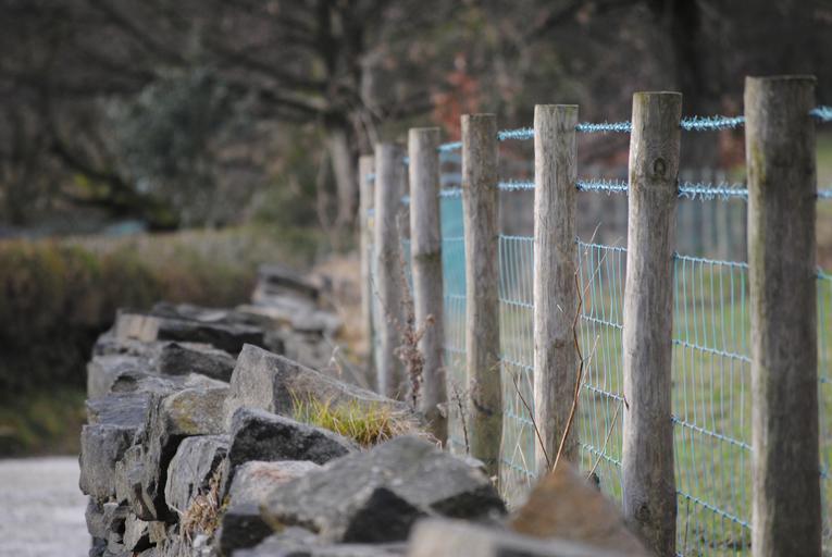 dřevěný plot podložený kameny